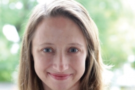 A woman with blonde hair smiles at the camera.